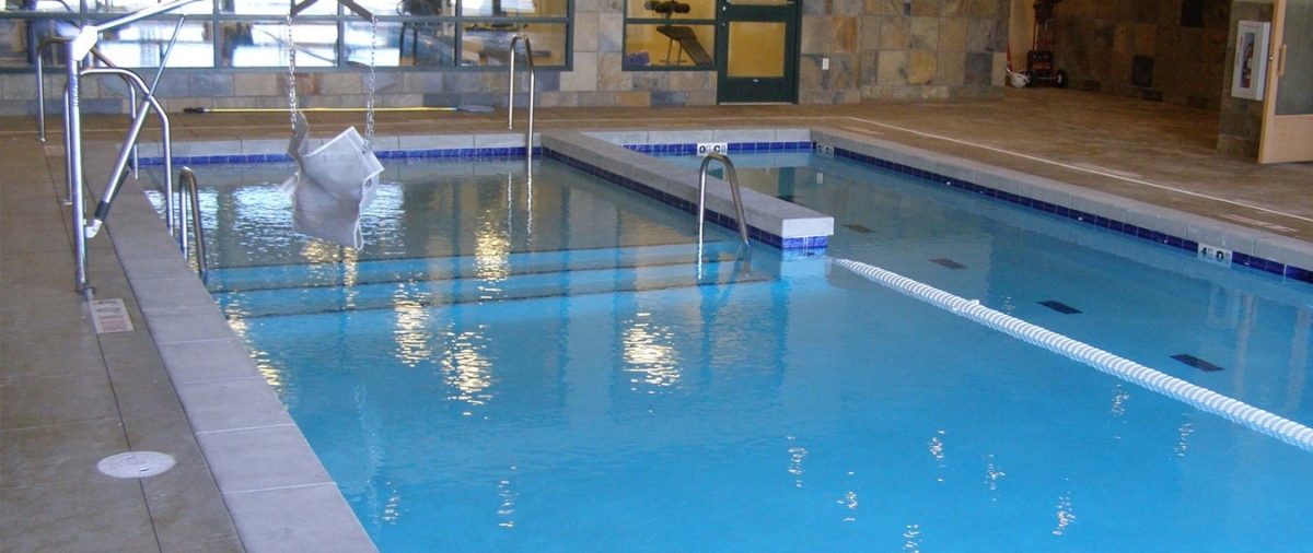 Backyard swimming pool with visible pump, filter, and heater equipment