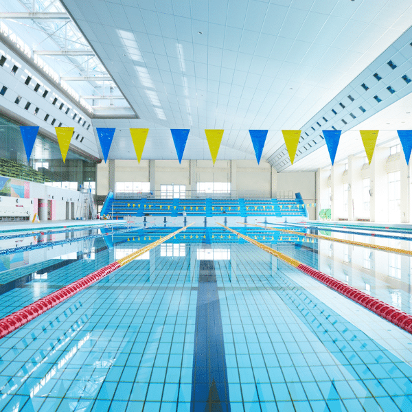 Busy indoor commercial pool with swimmers and lap lanes