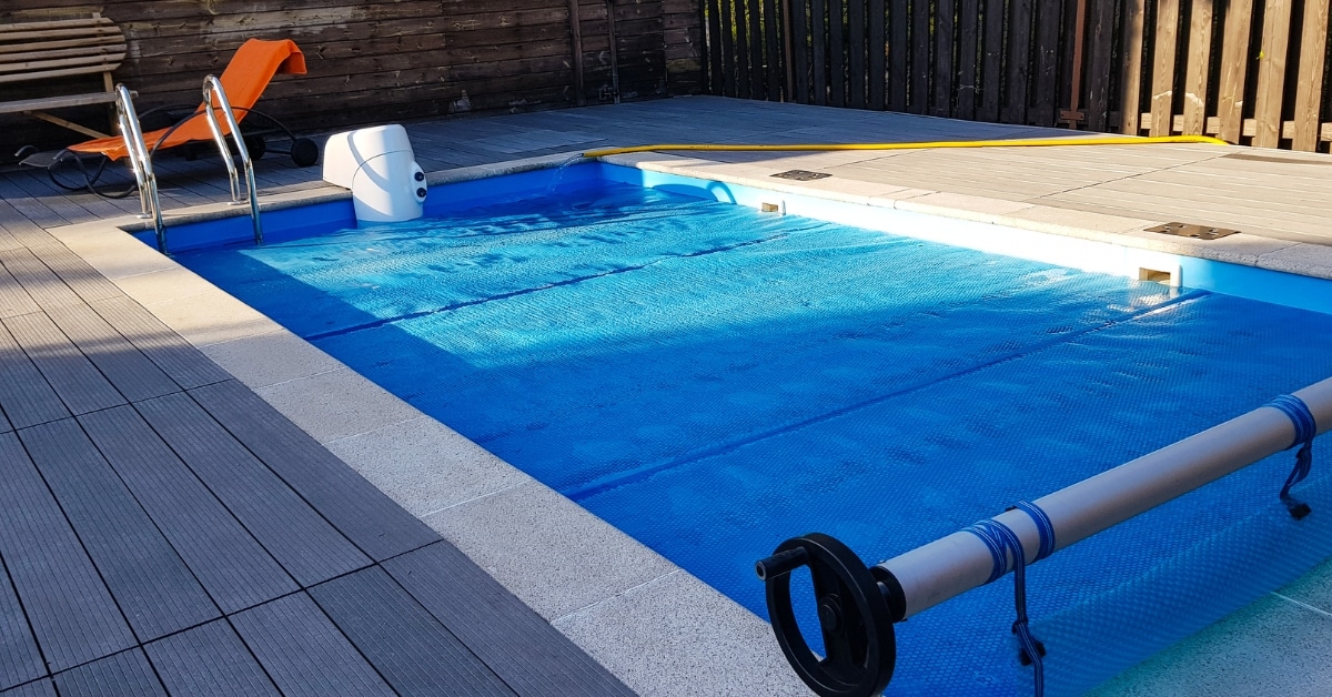 Professional pool technician installing winter pool cover